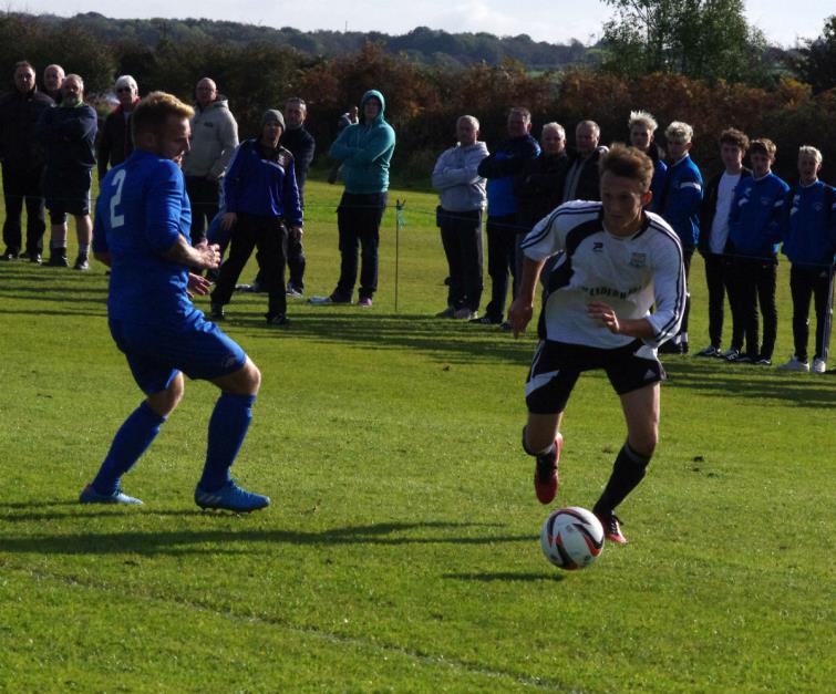 Hakin Uniteds Ben Steele takes on Merlins Bridge defender Chris Ormond